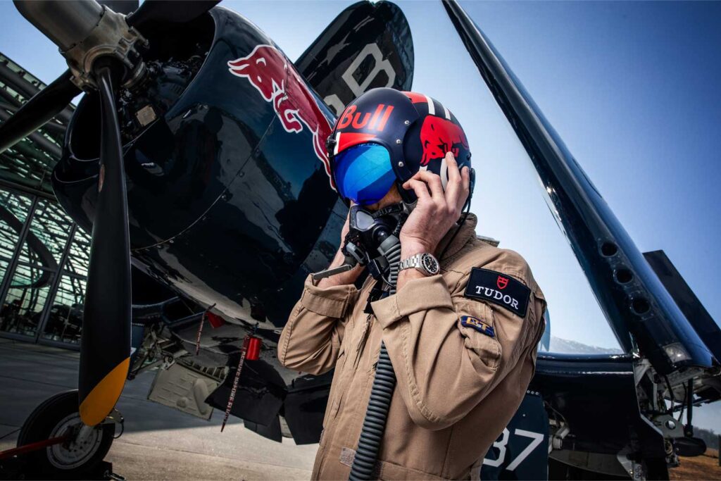 Ein Pilot mit Helm von Red Bull trägt eine Tudor