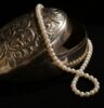 Schmuckdose aus Silber mit Perlenkette. © Anna Stampfli/ Unsplash.com