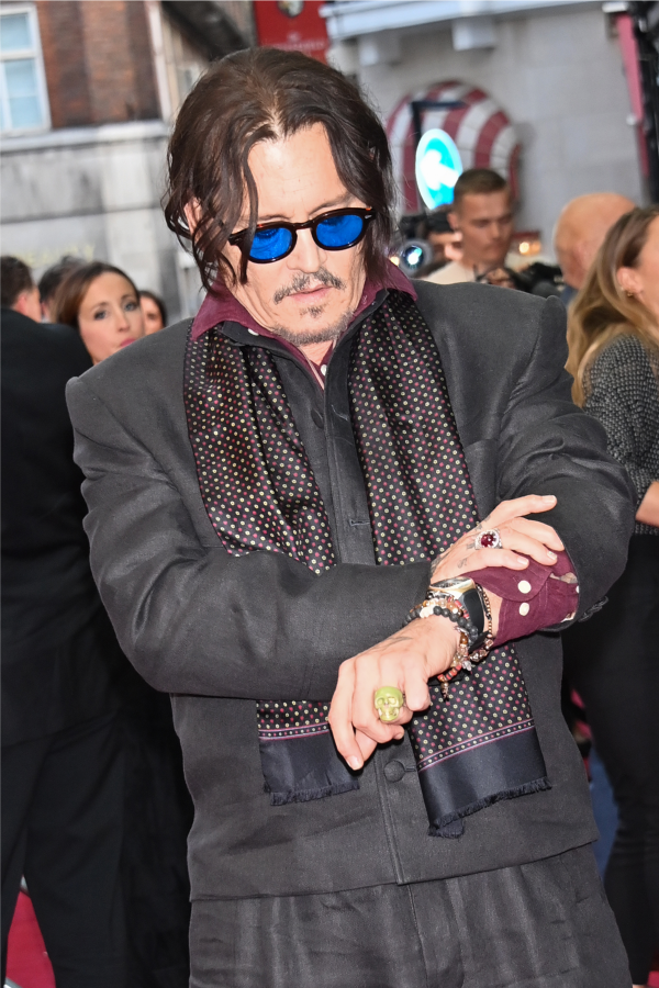 Johnny Depp schaut auf seine Uhr