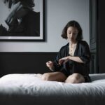 Fotomodell sitzt auf Bett und trägt Schmuck von Yana Nesper