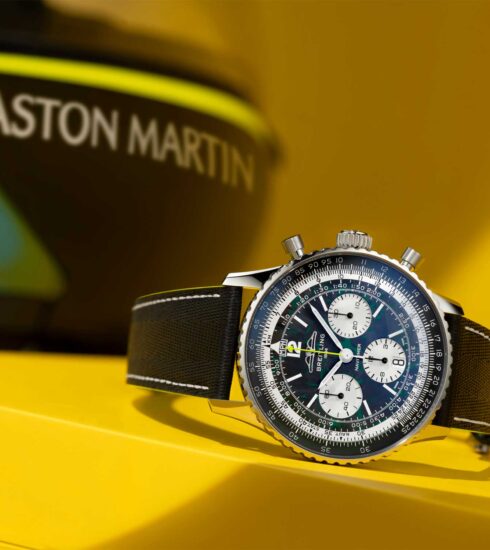 Schriftzug Aston Martin im Hintergrund der Uhr Navitimer B01 Chronograph 43 Aston Martin Aramco Formula One Team