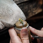 Hände eines Goldschmiedes aebeiten an einem Schmuckstück von Brusi