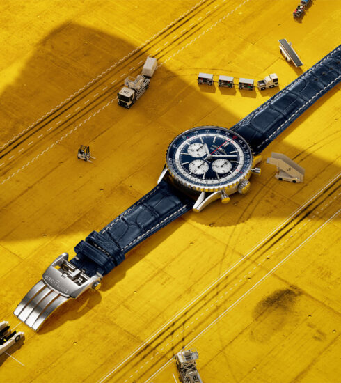 Navitimer B01 Chronograph 43 Tribute to Concorde von Breitling auf gelben Untergund mit miniaturisierten Flughafenobjekten