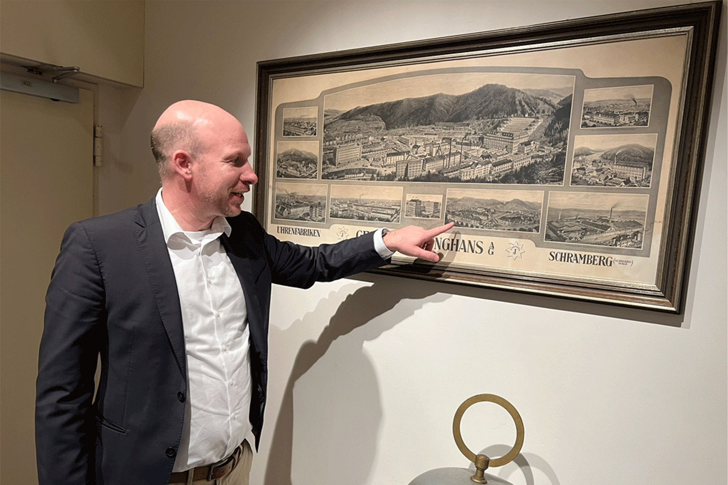 Hannes Steim (CEO Junghans) zeigt auf ein historisches Bild