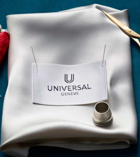 Logo von Universal Geneve auf Stoff mit Nähutensilien