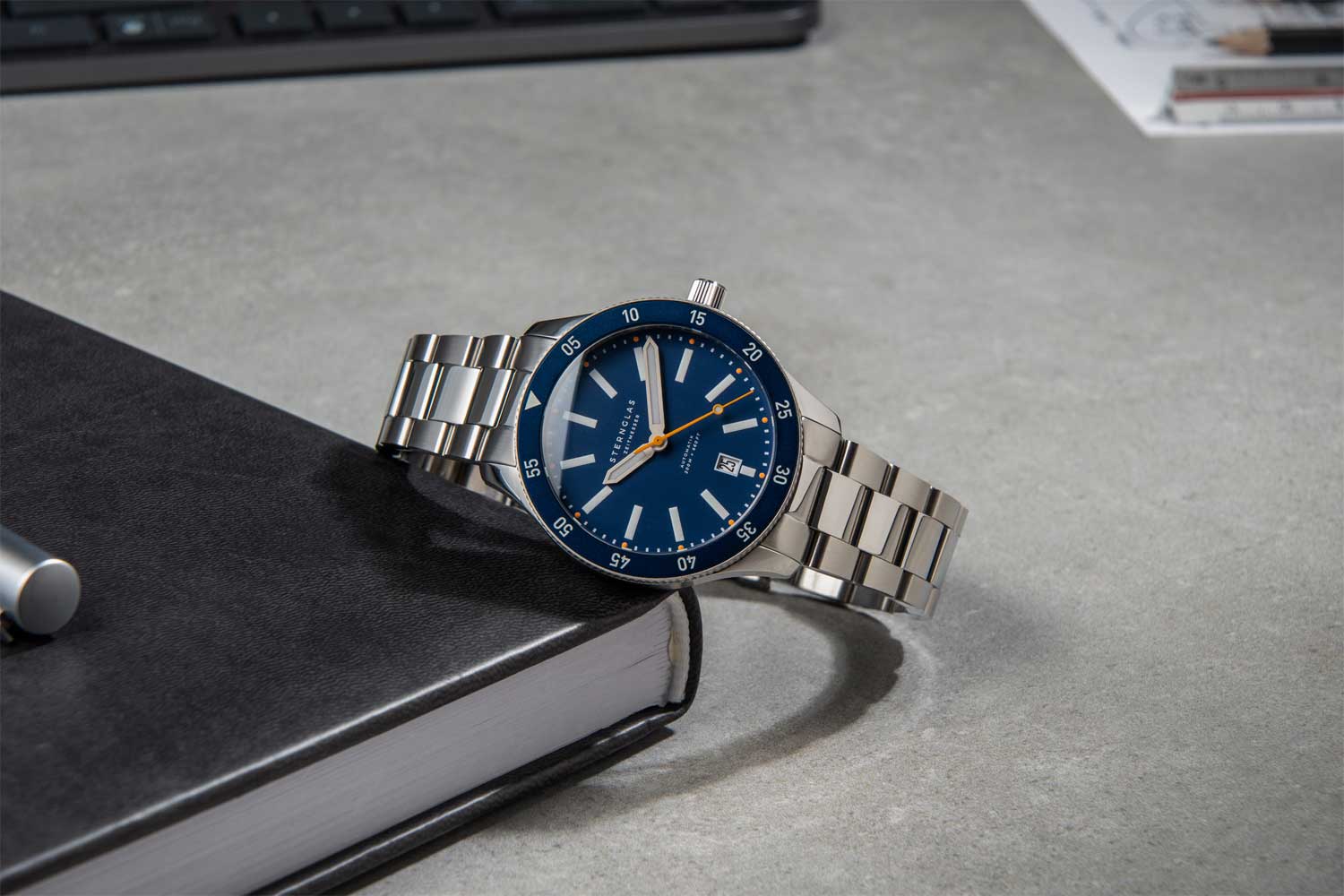 Marus 2.0 Edition Küste von Sternglas, auf einem Buch liegend