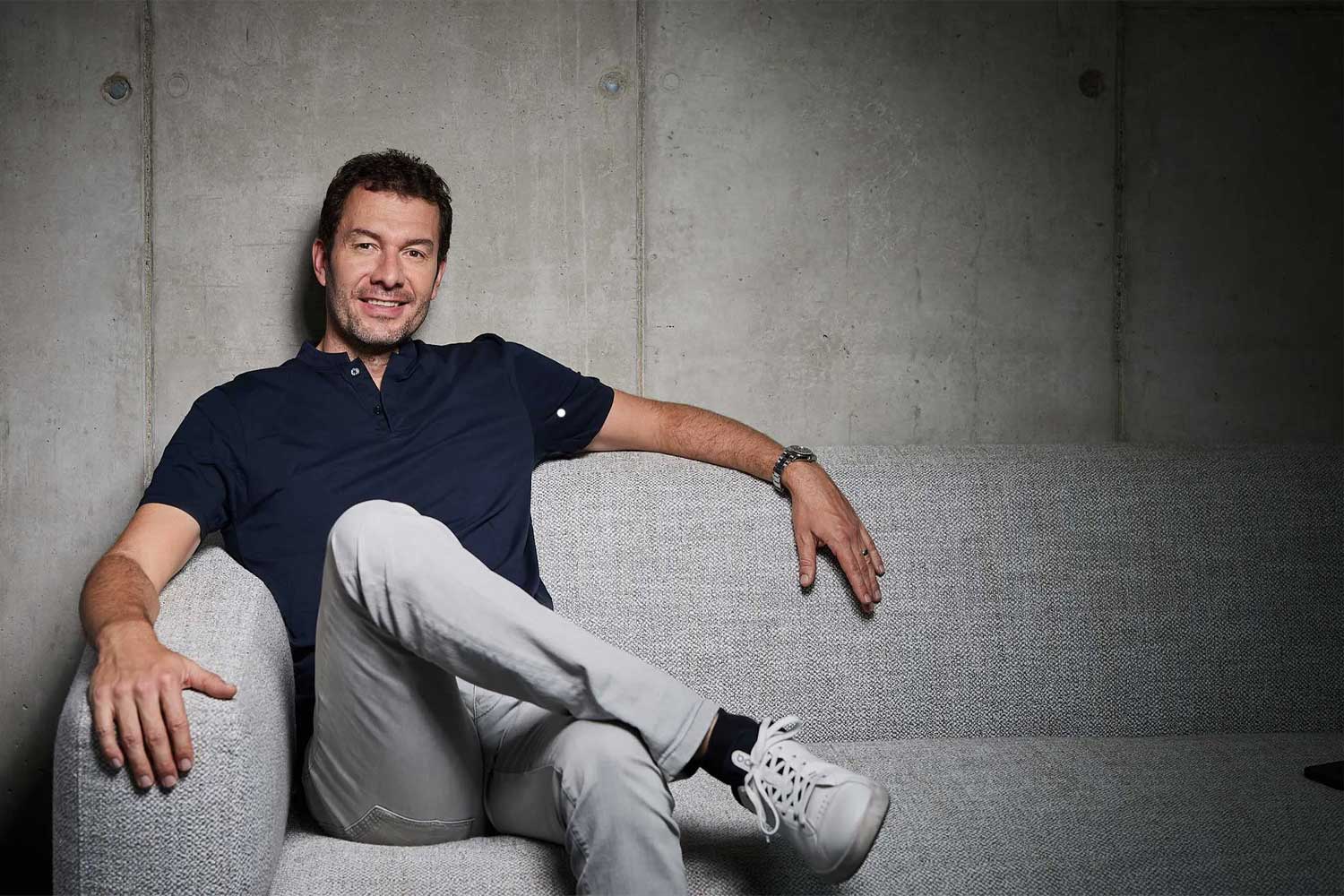 Tim Stracke auf einem Sofa sitzend