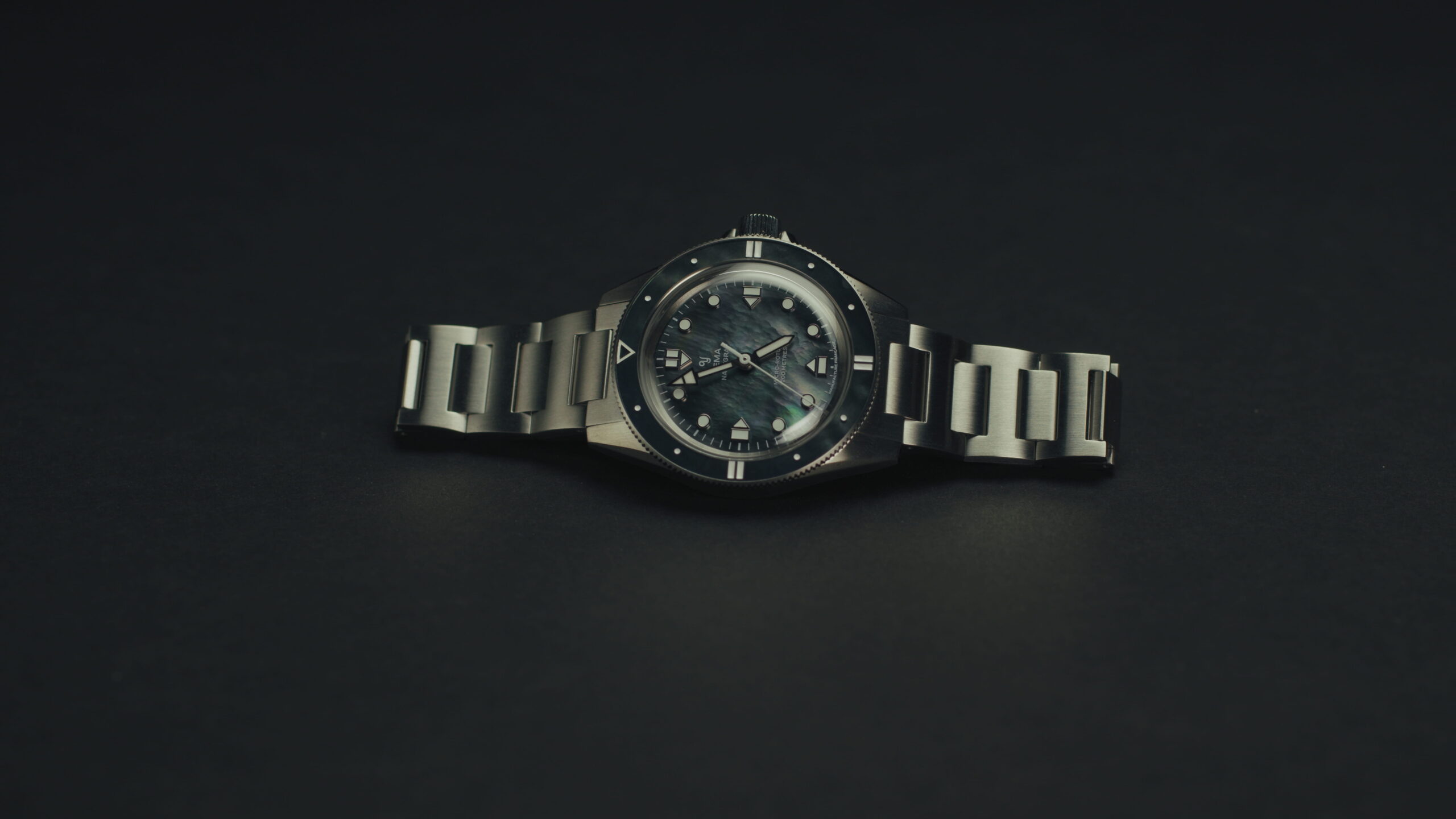 YEMA Navygraf Pearl CMM.20 photographed lying flat, featuring a mother-of-pearl dial and a stainless steel bracelet