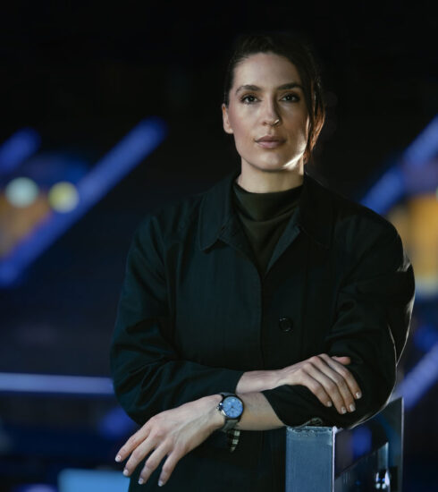 Andrea Petković steht auf einem Tennisplatz am Netz und trägt eine Sky von Tutima