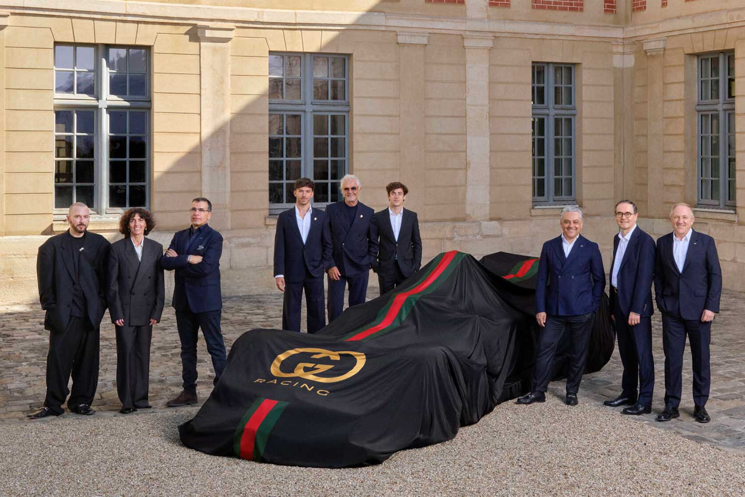 The Gucci Racing Alpine Formula One Team's camouflaged race car, alongside representatives from both companies