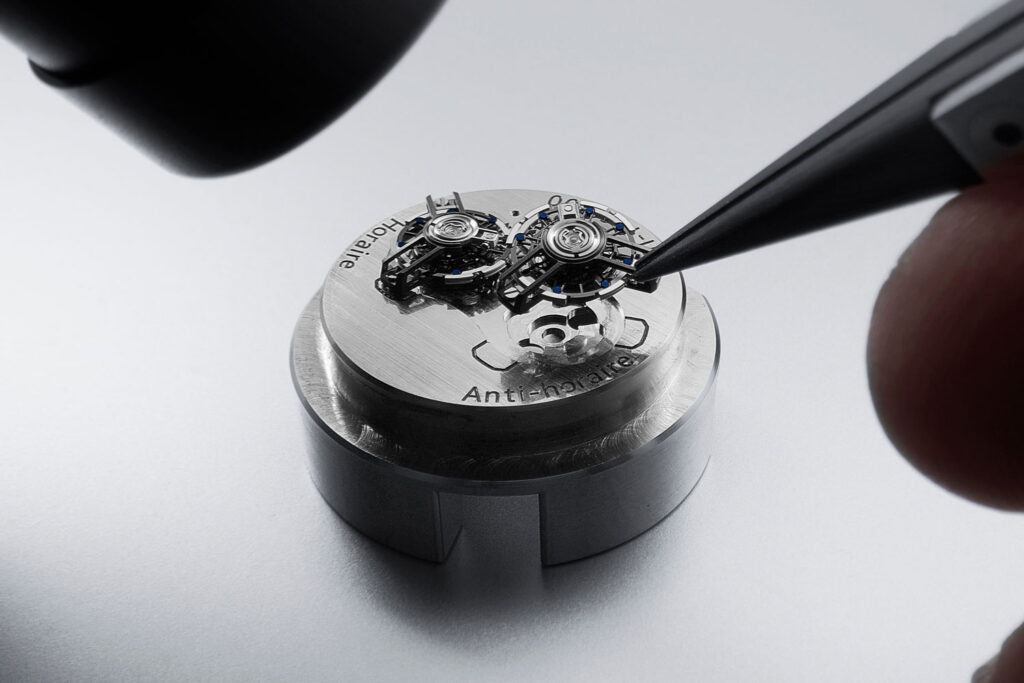 Händer montieren das Uhrwerk der Super Freak von Ulysse Nardin