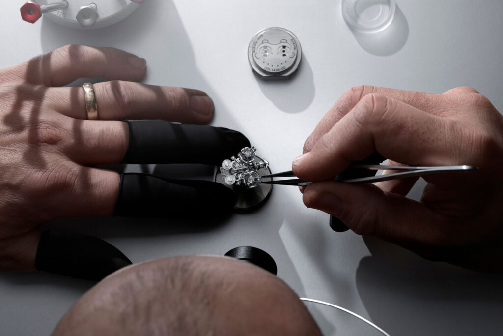Händer montieren das Uhrwerk der Super Freak von Ulysse Nardin