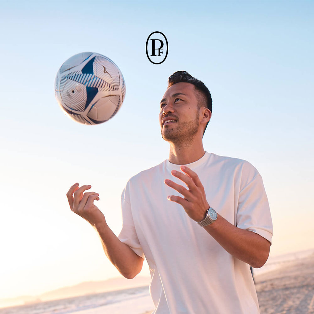 Maya Yoshida wirft einen Fußball hoch