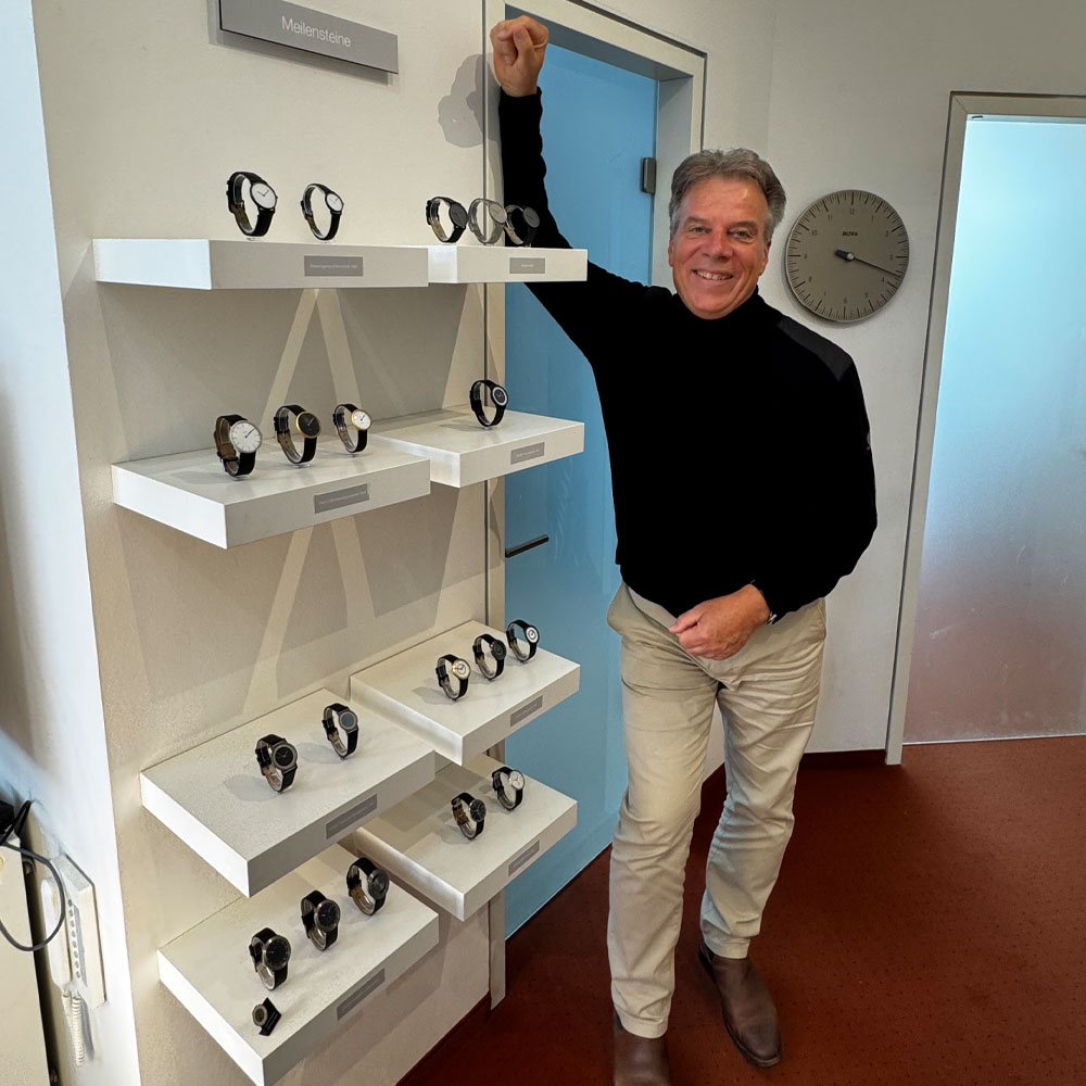 Klaus Botta steht in seinem Atelier vor dem Regal mit den Meilensteinen