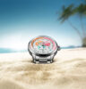 Freedom GMT Enjoy Life Holiday Limited Edition von Norqain steckt im Sand an einem Palmenstrand