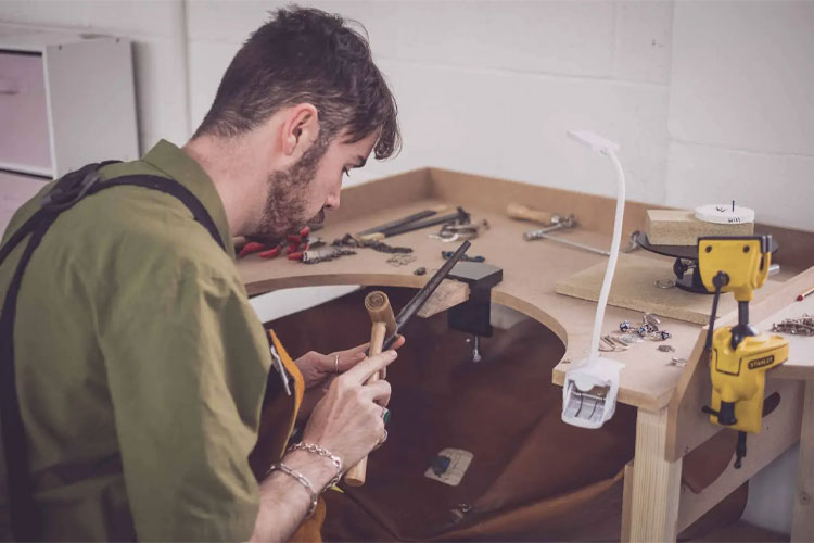 A man is sitting at a workbench
